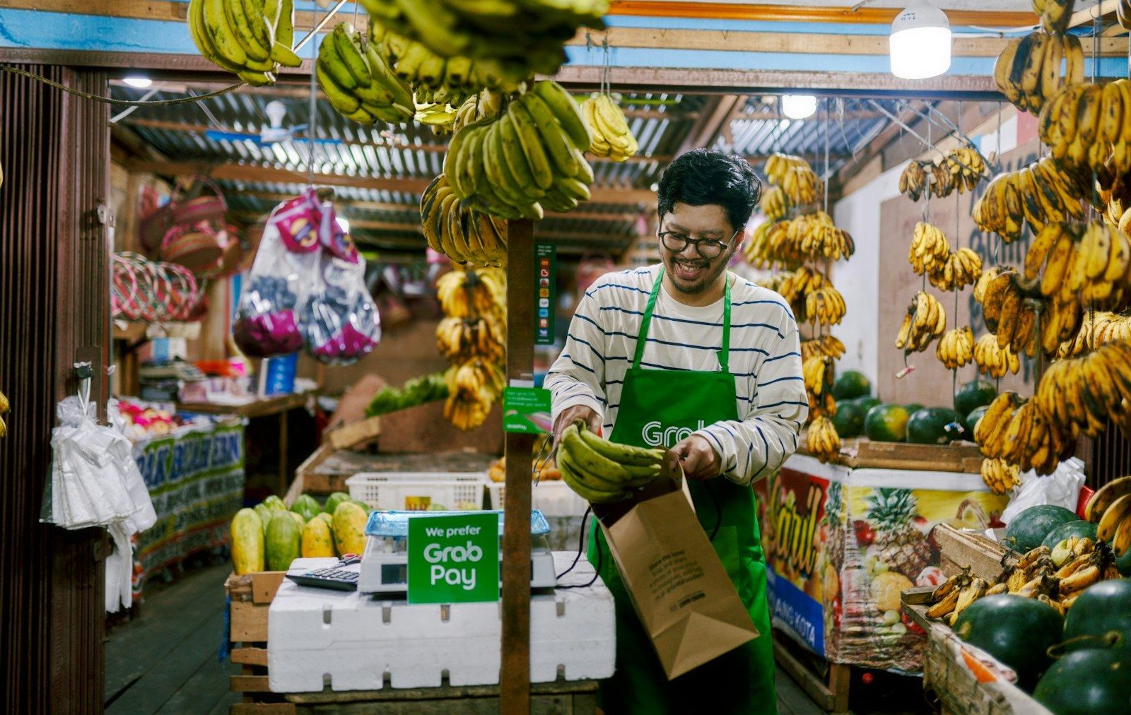 a man holding a bag of bananas in a store